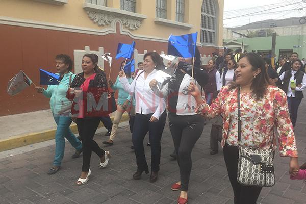 Candidata panista se cuelga de desfile escolar para promoverse