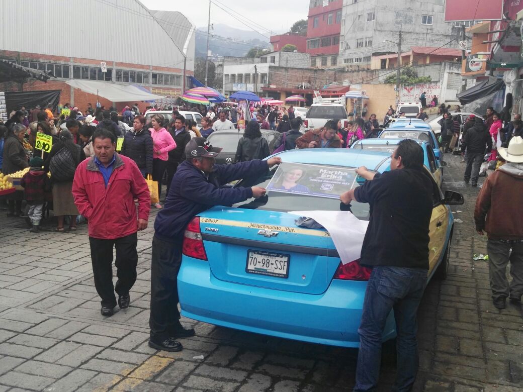 Inspectores de la SIMT pegan propaganda de Martha Erika en taxis