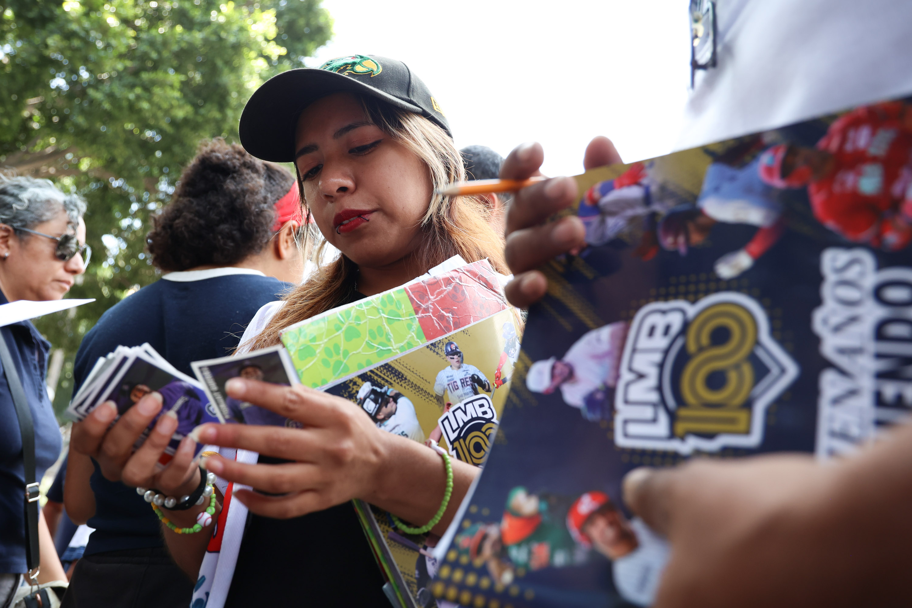 Beisbolistas conectan jonrón al intercambiar estampas en el zócalo de Puebla