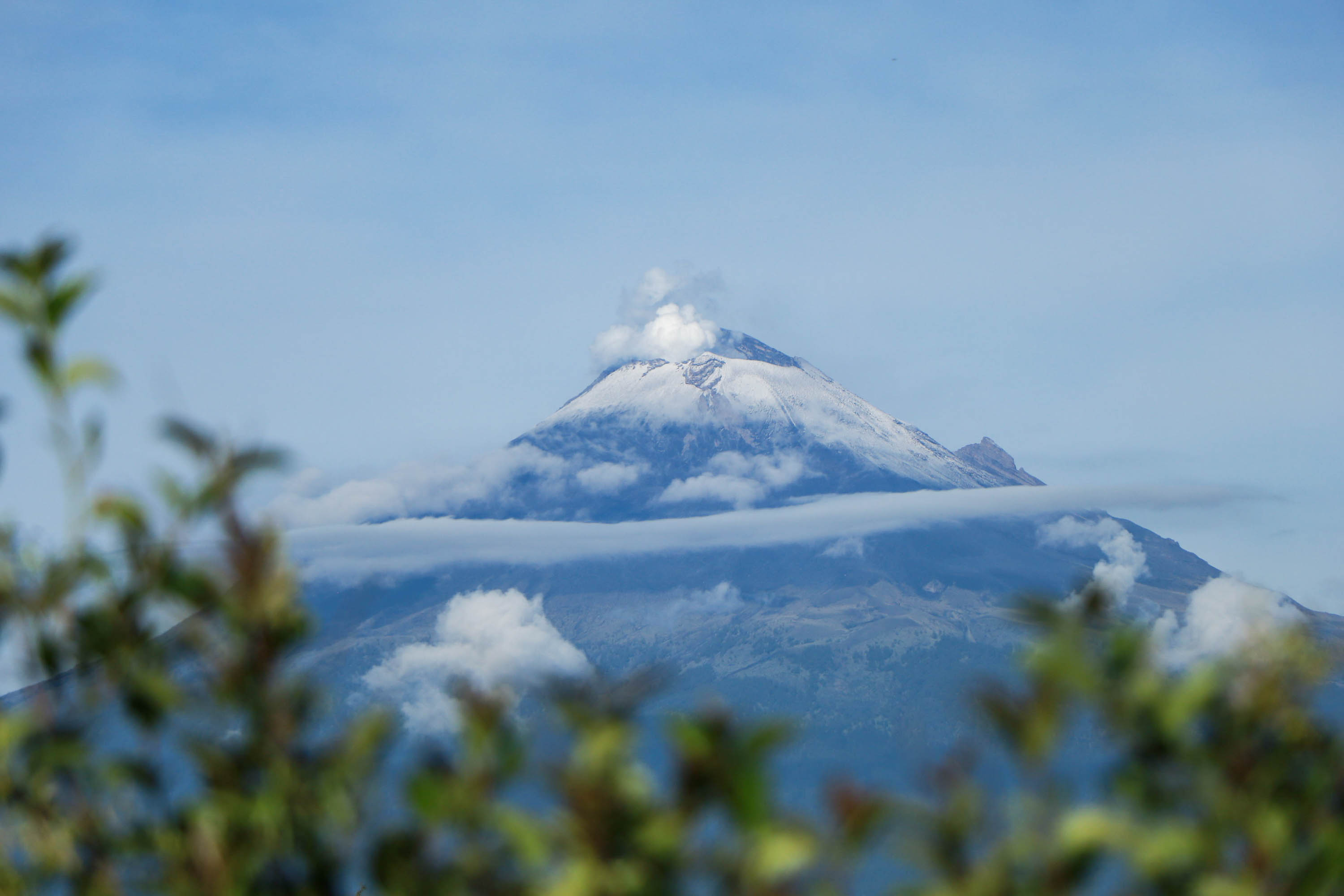 Amanece el Popocatépetl cubierto de nieve y rodeado de nubes