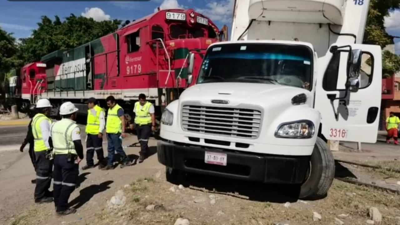 Camión de refrigeración es arrastrado por el tren en Texmelucan