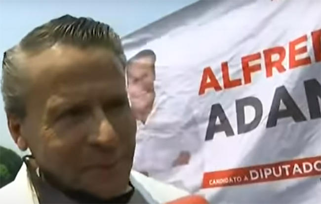 Captan a Alfredo Adame repartiendo volantes en la carretera Picacho-Ajusco