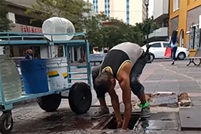 VIDEO Cachan a vendedor de aguas llenando vitroleros en coladera