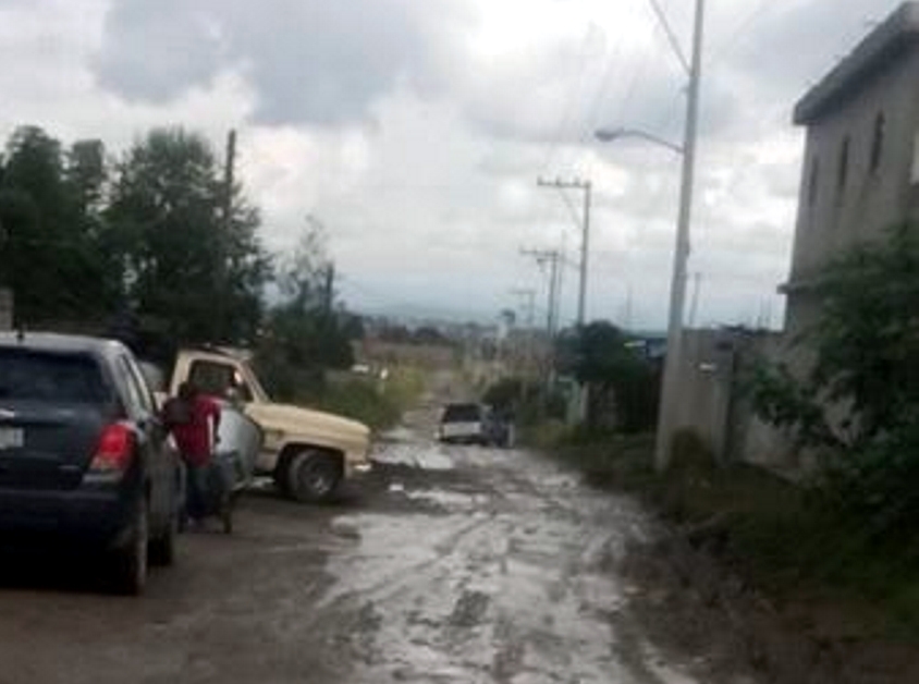 Con bloqueo, vecinos exigen reparación de camino en Almecatla