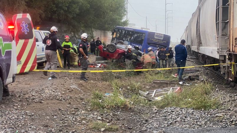 Tren se lleva camión de pasajeros y auto; hay un muerto