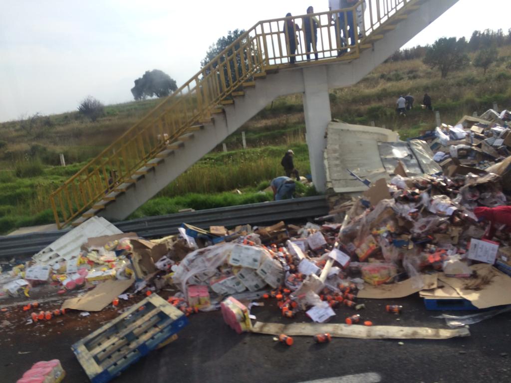 Rapiña de abarrotes tras camión volcado en la México-Puebla