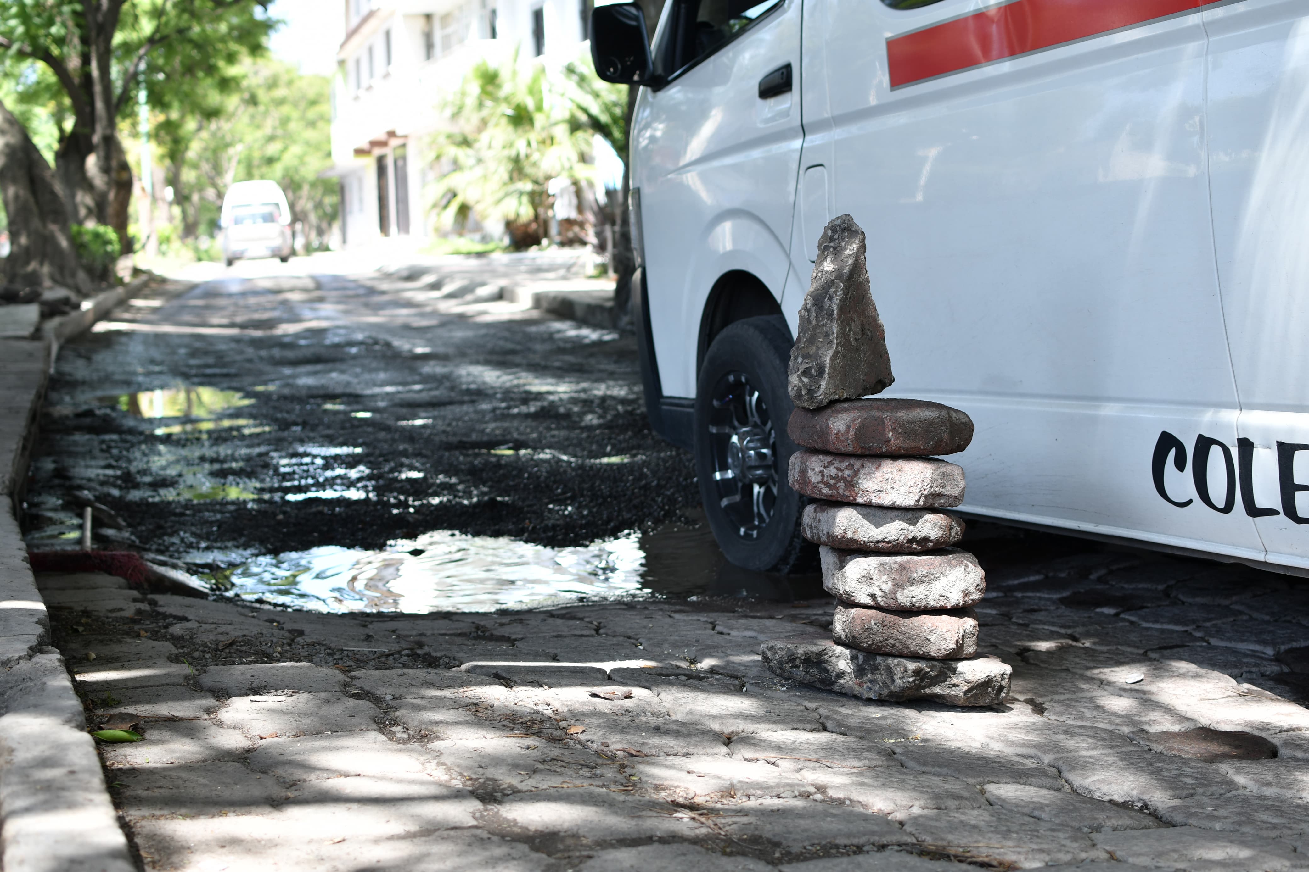 Con montículo de adoquín anuncian a los automovilistas para no caer en baches