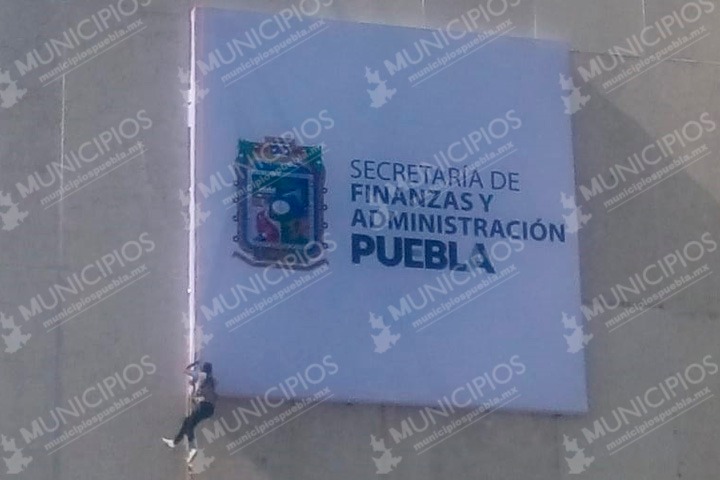 Sin protección y colgado de un mecate cambia letrero de SFA