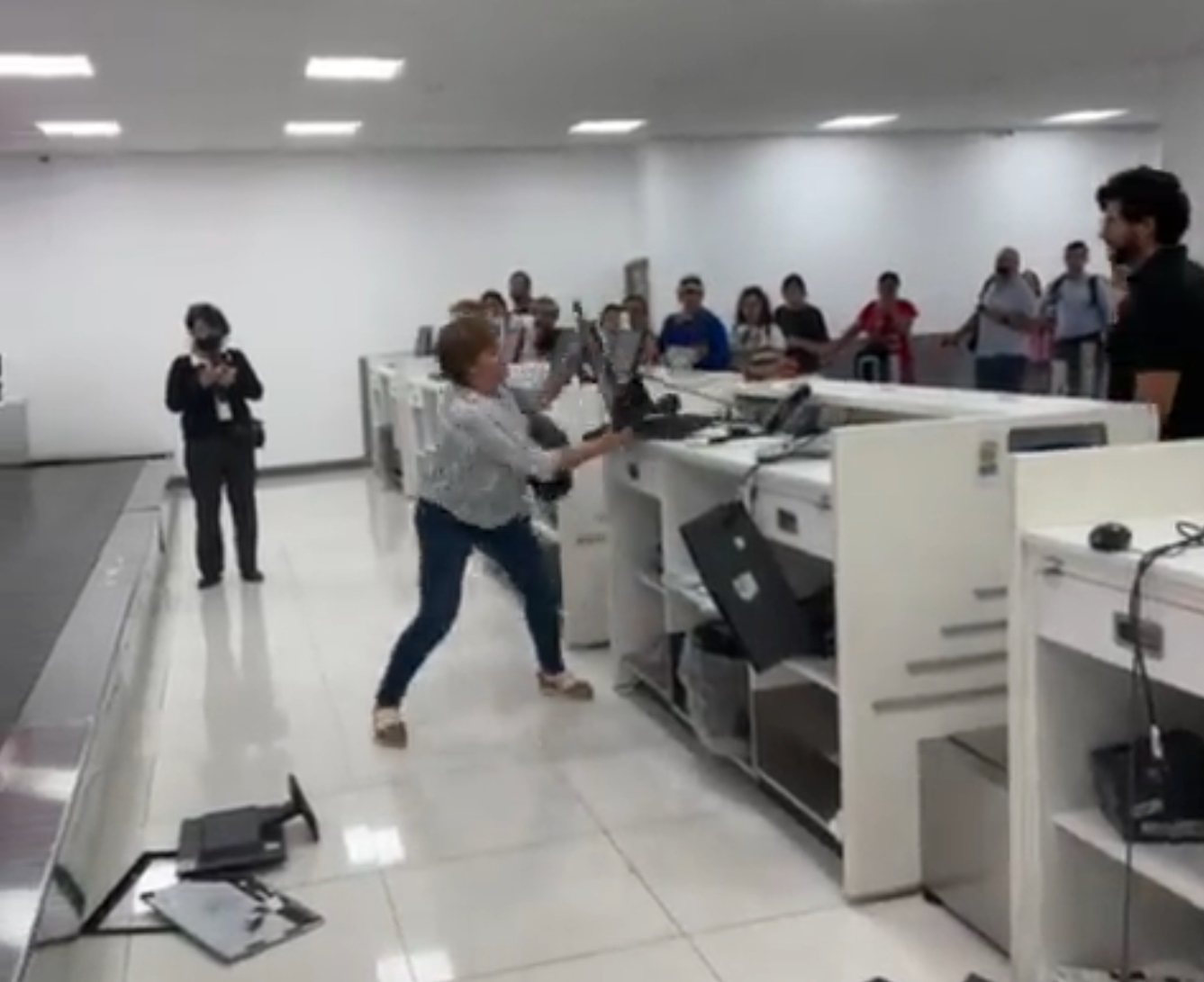 VIDEO Mujer destruye computadoras en mostrador de Volaris en el AICM