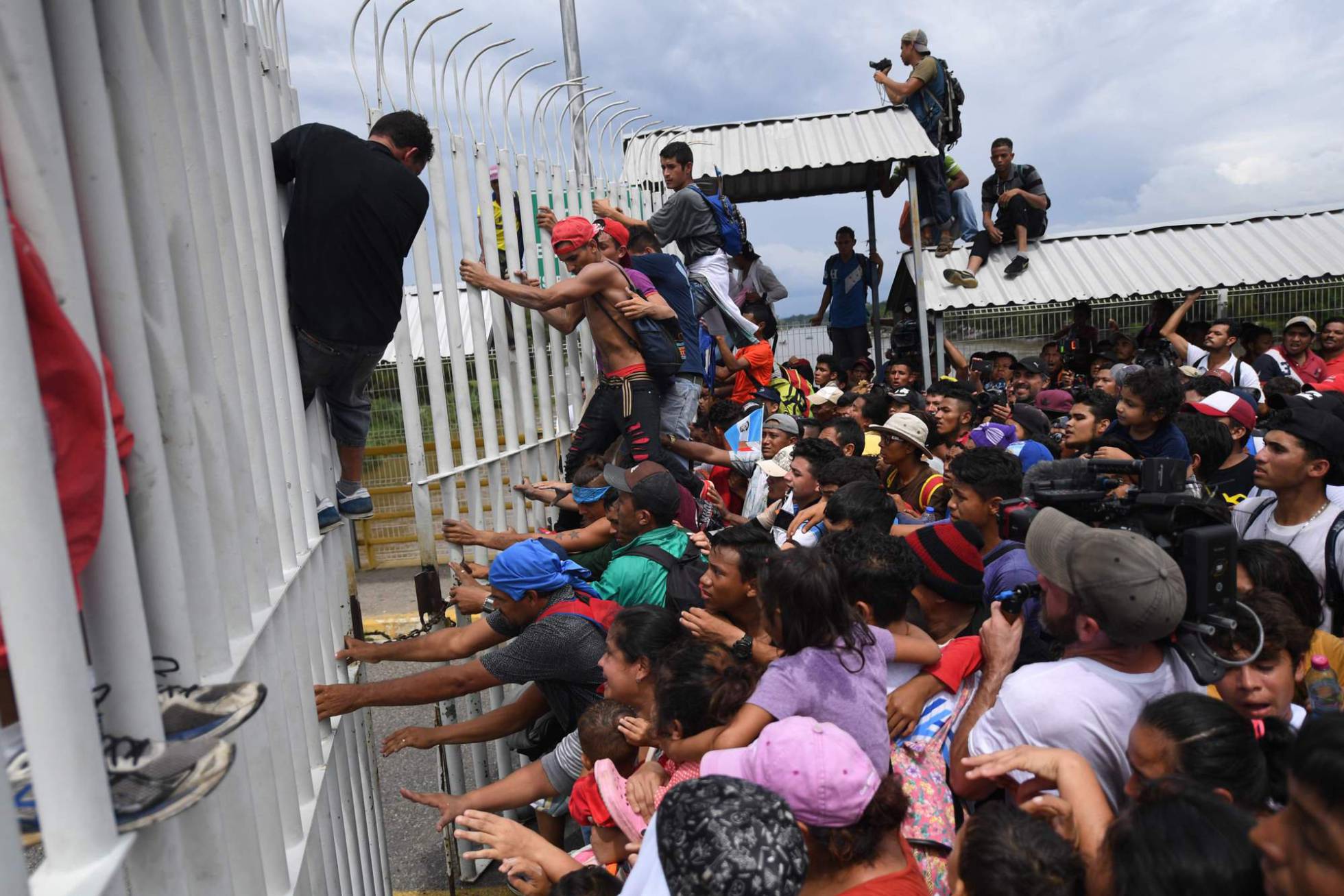 VIDEO Migrantes hondureños derriban valla fronteriza 