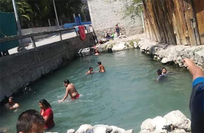 En plena contingencia en Tehuacán van a nadar en canal de agua